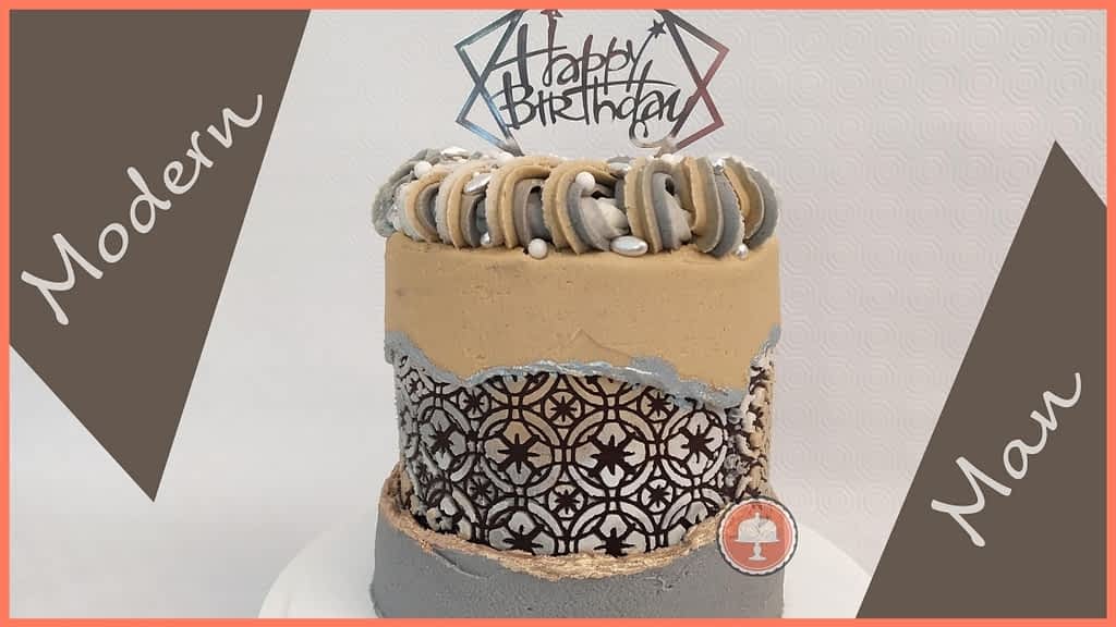this birthday cake for men is an example of a trendy cake design for men which has a fault line design with a rich pattern revealed behind the fault line, the colors are masculine and has a sliver cake topper Happy Birthday on top