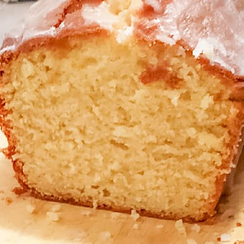 lemon loaf cake showing the inside of the cake with fluffy lemon and a sugar drizzle on top