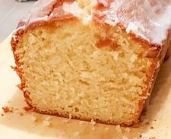 lemon loaf cake showing the inside of the cake with fluffy lemon and a sugar drizzle on top